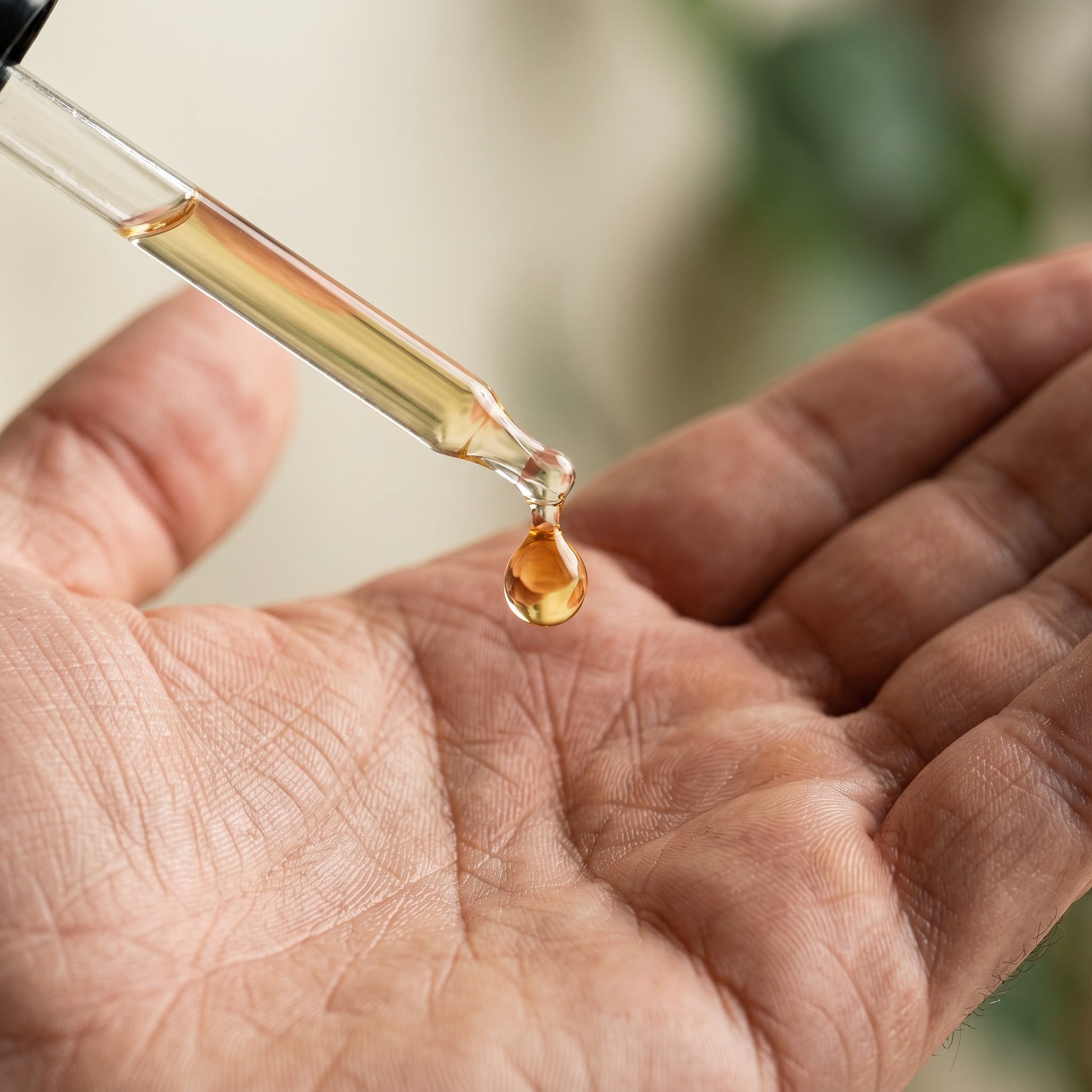 Amber serum drop on the palm of a hand